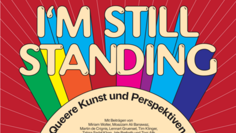 Das grafisch gestaltete Plakat mit dem Titel der Ausstellung Regenbogenfarben im Hintergrund.