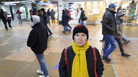 Eine Frau steht am Dortmunder Hauptbahnhof und blickt in die Kamera