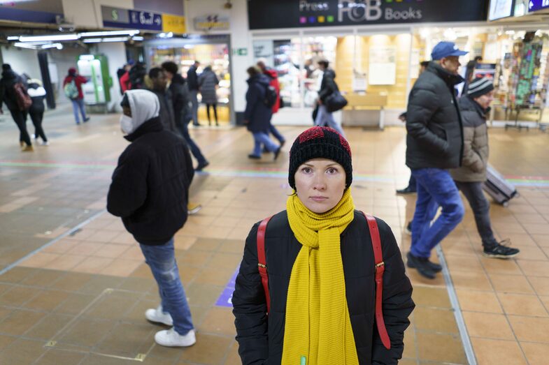 A woman stands at Dortmund Central Station and looks into the camera