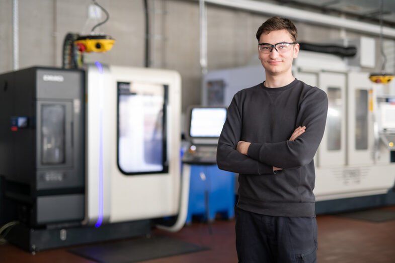 Foto von einem Jungen, der vor einer Maschine in einem Labor steht.