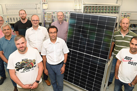 A group of nine people stand around a solar panel in a laboratory at Fachhochschule Dortmund.